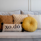 Almofada Decorativa Baguete com Frase Xodó e Pompons 52 x 24 cm